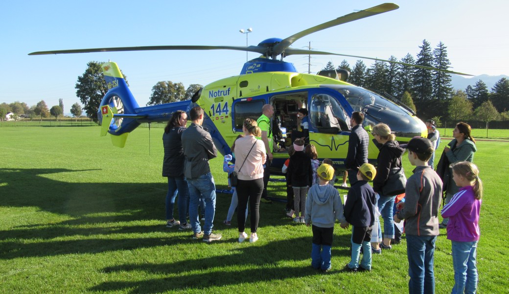 begeisterte Kinder mit Eltern beim Rettungshelikopter der Alpine Air Ambulance