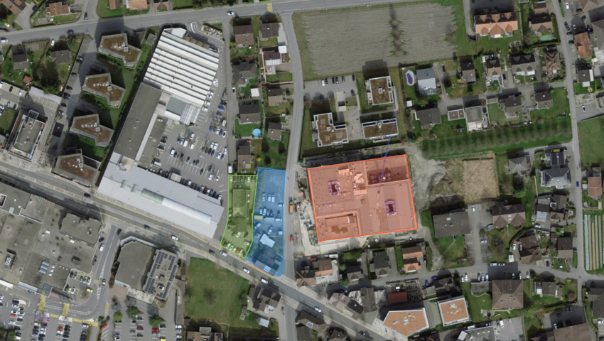 Die Ansicht zeigt in Grün die Liegenschaft Carrosserie Leopold, in Blau die Liegenschaften, die bereits der politischen Gemeinde gehören und in Rot das benachbarte neue Zentrum Zehntfeld.