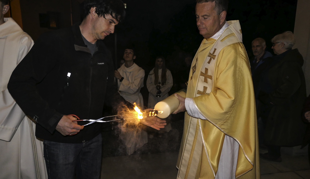 Michael Benz und Priester Simon Niederer beim Entzünden der gesegneten Osterkerze. 