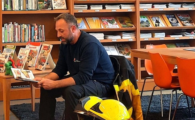 Ein Feuerwehrmann in der Bibliothek