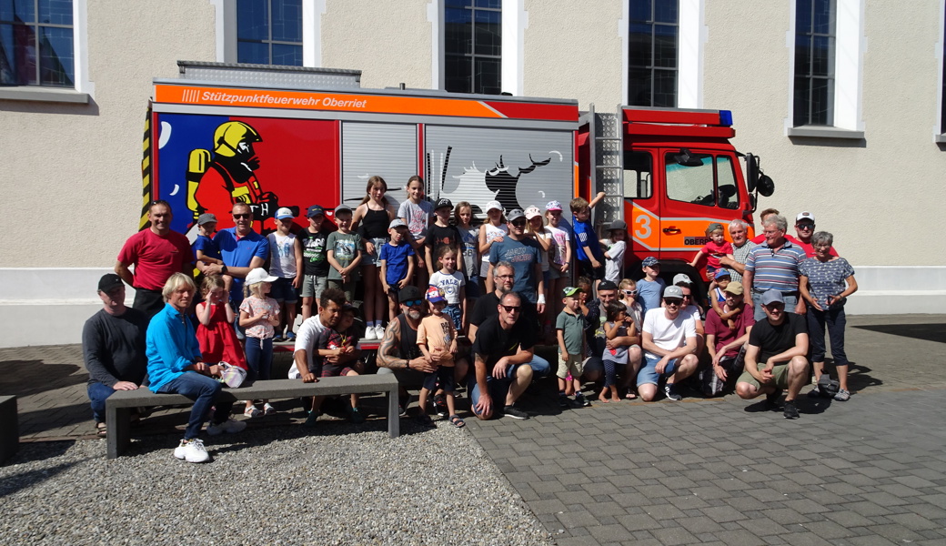 Die fröhliche Kinderschar mit ihren Begleitpersonen vor dem Feuerwehrauto Die fröhliche Kinderschar mit ihren Begleitpersonen vor dem Feuerwehrauto