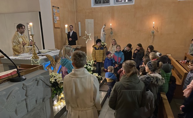 Kinder öffnen im Weihnachtsgottesdienst Türchen