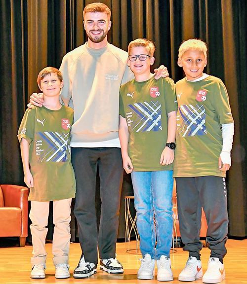 Betim Fazliji mit Kickern des Schulfussballteams Diepoldsau-Marbach (von links): Sam Tenisch, Noël  Hasler und Nico Reis.