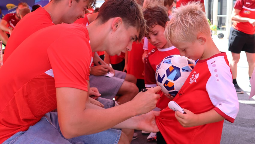 Luca Celentano (links) gibt einem Junior ein Autogramm.