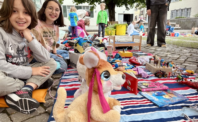 Kinder feilschen im Museumsgarten um aussortierte Spielsachen