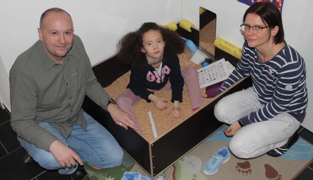 Andrina sitzt gern in der Chriesischtei-Chischte und lässt es rieseln. Der Sandkastenersatz diene der Körperwahrnehmung, erklären Benno und Katharina Dellai-Schöbi. Während dem Kind die Motivation, sich für irgendetwas zu interessieren, oft fehlt, dürfen die Eltern nicht nachlassen.