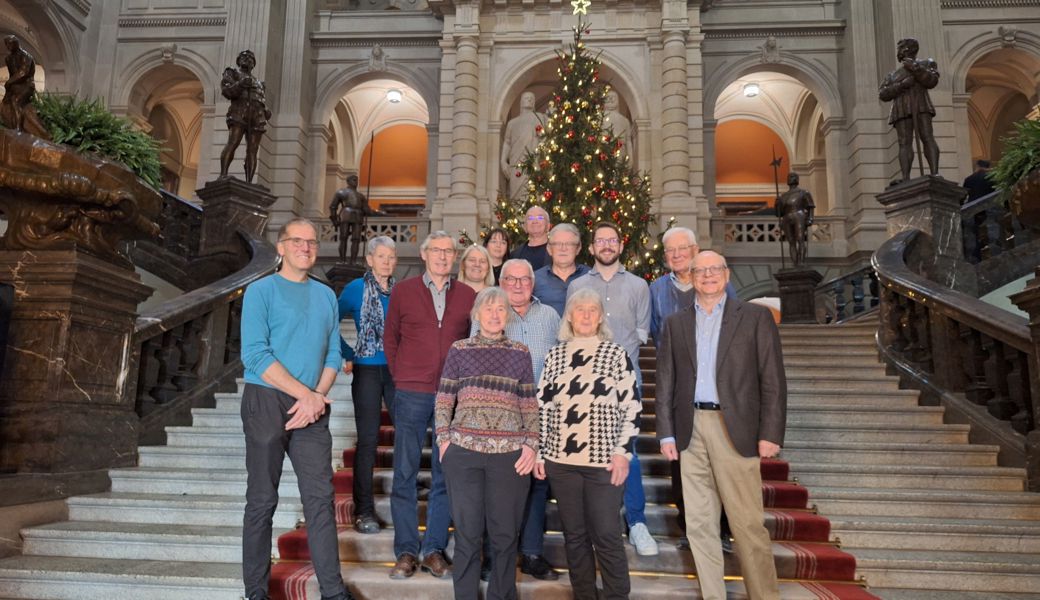 Gruppenbild in der Kuppelhalle vor dem grossen Christbaum und den drei Eidgenossen