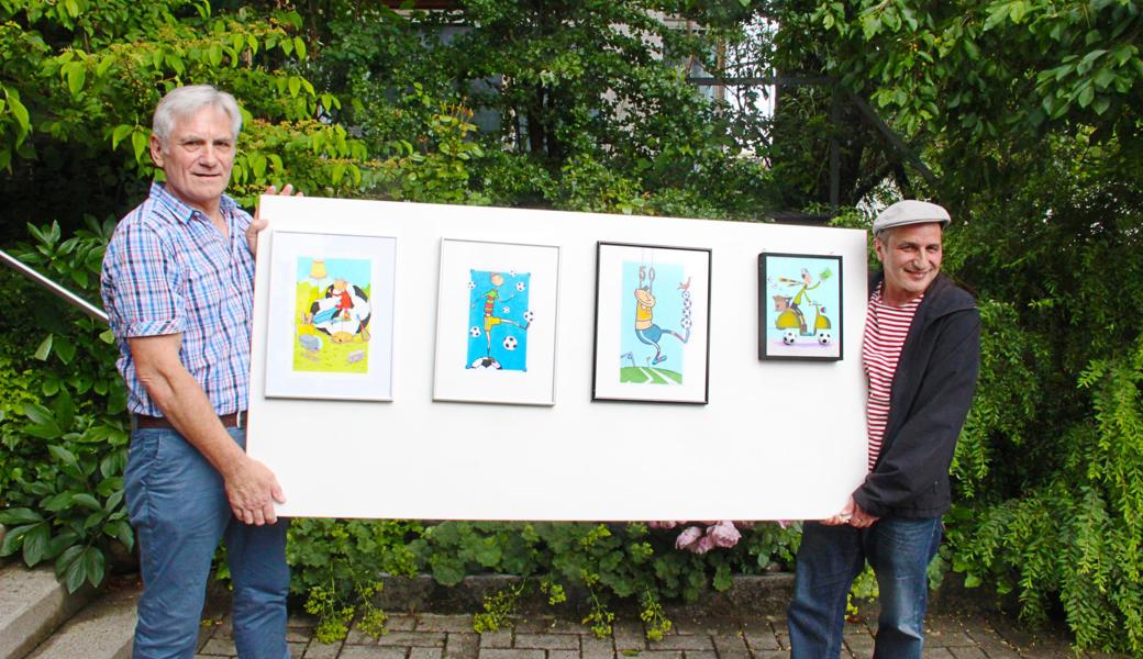 Marcus Gächter (links) und Patrick Steiger zeigen vier von 26 Bildern, die im Festzelt ausgestellt werden. 