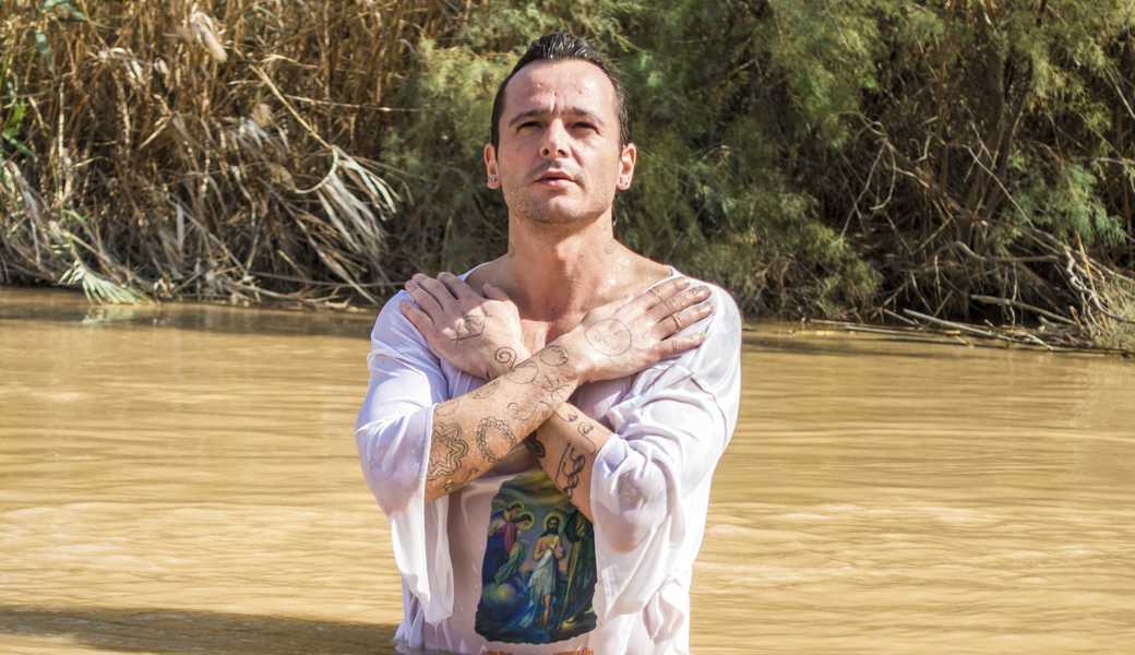 Jericho, Israel - November 2, 2015: Organised baptism for group of pilgrims in river of Jordan, the place which is believed that Jesus was baptized
