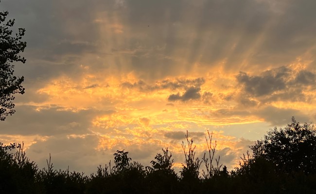 Der Tag verabschiedet sich mit goldenen Strahlen zwischen den Wolken