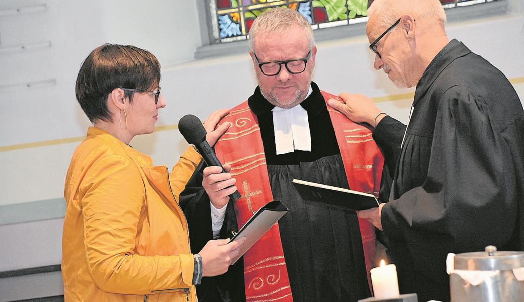 Martina Tapernoux und Koni Bruderer segnen ihren Kollegen Klaus Stahlberger. 