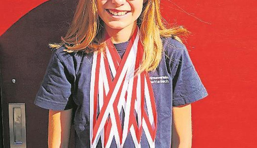 Die erfolgreiche Janine Schelling zeigt ihre Medaillen.