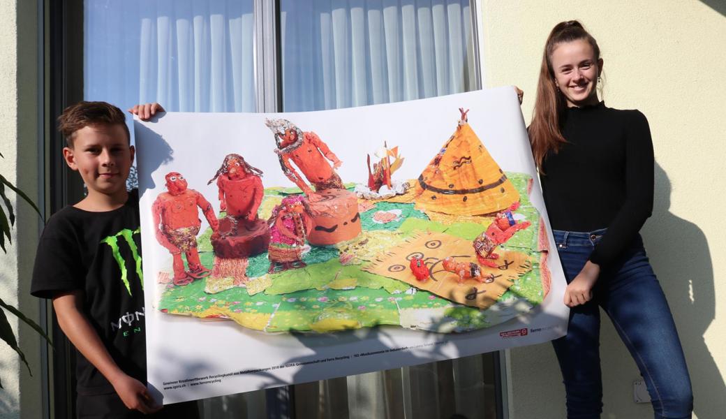 Lorena Simone und ihr Bruder Enea zeigen ein Abbild vom Kunstwerk «Musikzeremonie im Indianerdorf». Das Original wurde Pro Infirmis gesponsert. 