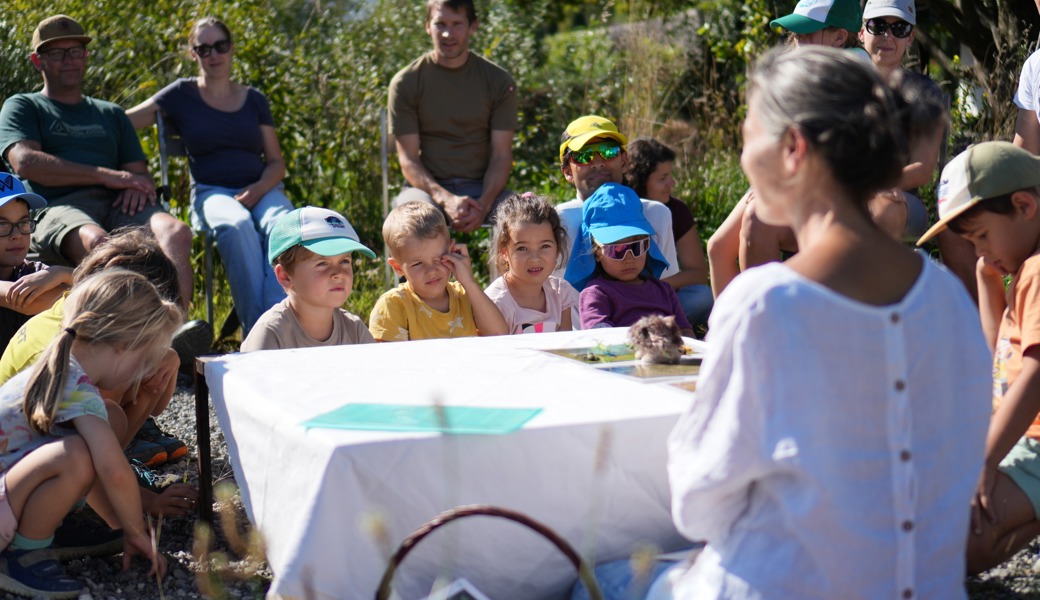 Kursleiterin Isabelle Saluz erzählt den Kindern, wie ein Igel nachts durch den Garten streift, wo er unterwegs ist und was er dabei entdeckt.