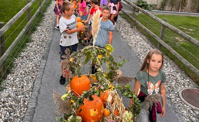 Kinder ziehen 16 geschmückte Leiterwagen durch das Dorf