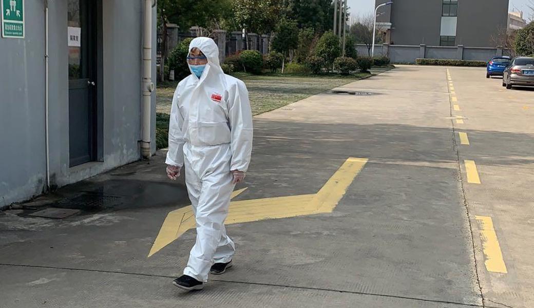 Ein Wachmann kontrolliert im Plaston-Werk in Jiaxing jeden, der das Betriebsgelände betritt und misst die Temperatur. 