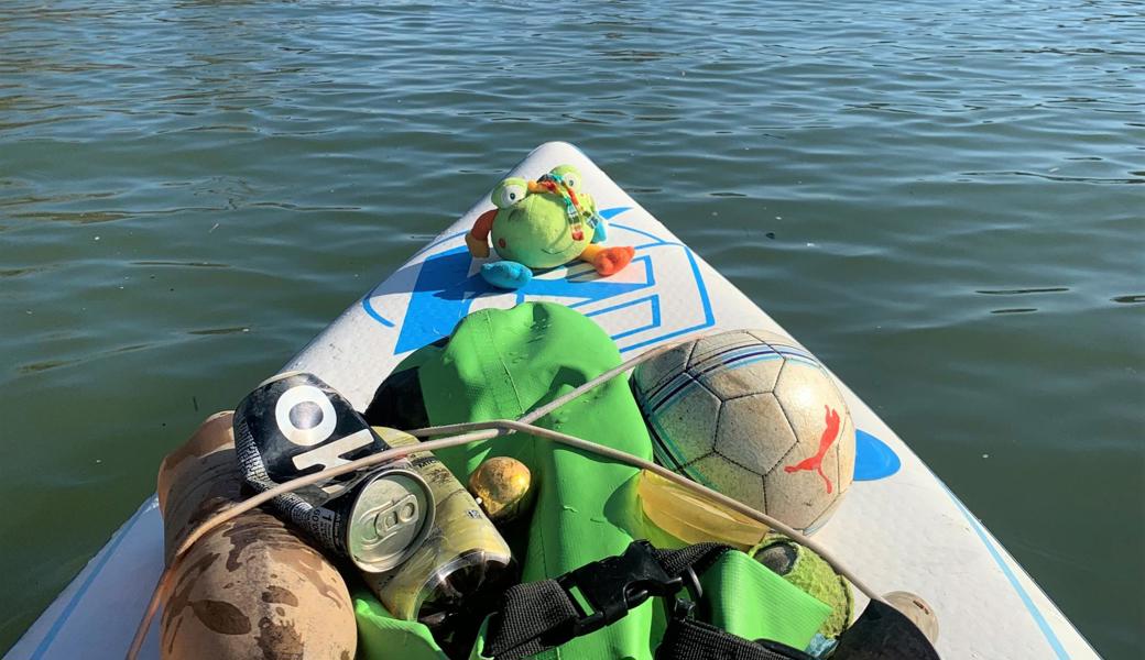 Auf dem Stand Up Paddle sammelt sich Abfall, der im Wasser trieb und sich am Ufer verfing.