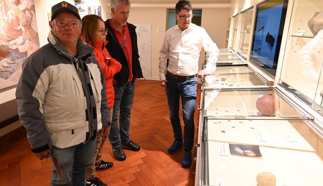 Claudio Senn (rechts) zeigt Besuchern im Museum Montlingen Silbermünzen aus der Römerzeit.