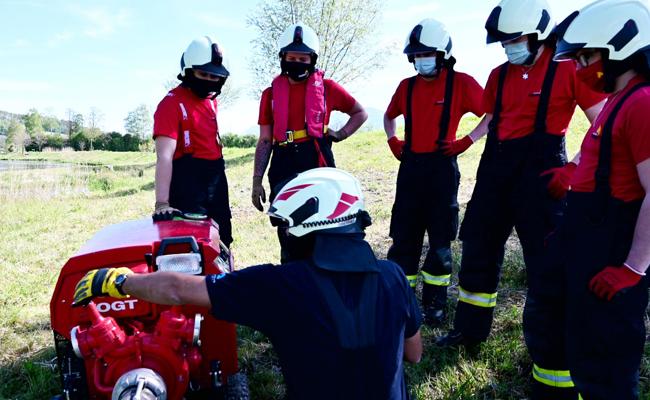 Neue Feuerwehrleute lernen, wie man mit der Motorspritze löscht