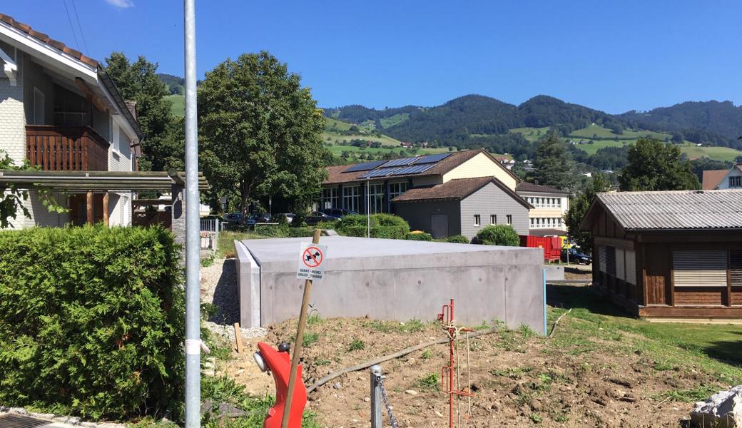 Der neue «Bunker», eine Veloparkieranlage aus Beton, ist sehr nahe bei den Häusern. Weil die Oberstufe (im Hintergrund) mehr Schulraum erhält, verschwindet das zum Dauerzustand gewordene Provisorium (rechts).