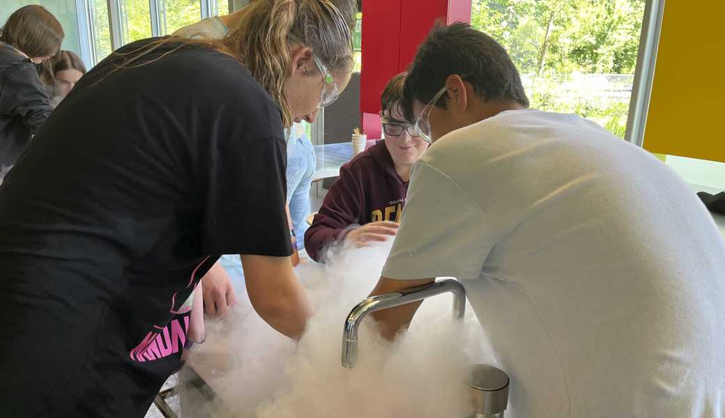 Die Schülerinnen und Schüler aus Heerbrugg stellen mit rauchendem, flüssigem Stickstoff Himbeerglace her. 