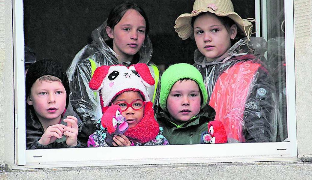 Dass Kinder gruppenweise aus einem der Schulhausfenster blicken, ist Teil der Inszenierung. 