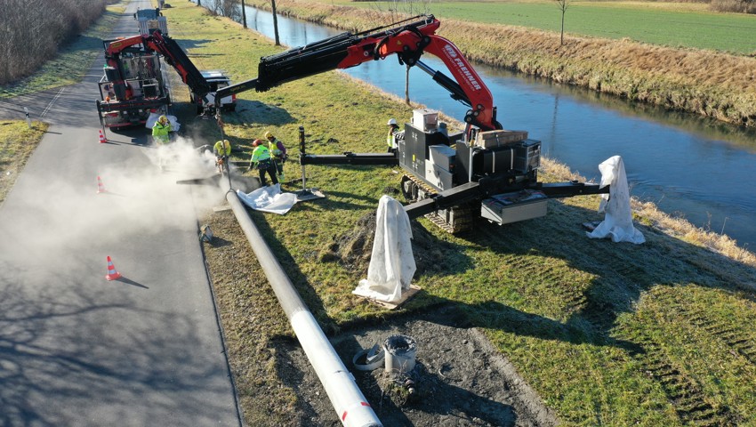 Ein abgelegter Betonmast wird zersägt, um für den Abtransport bereitgemacht zu werden.