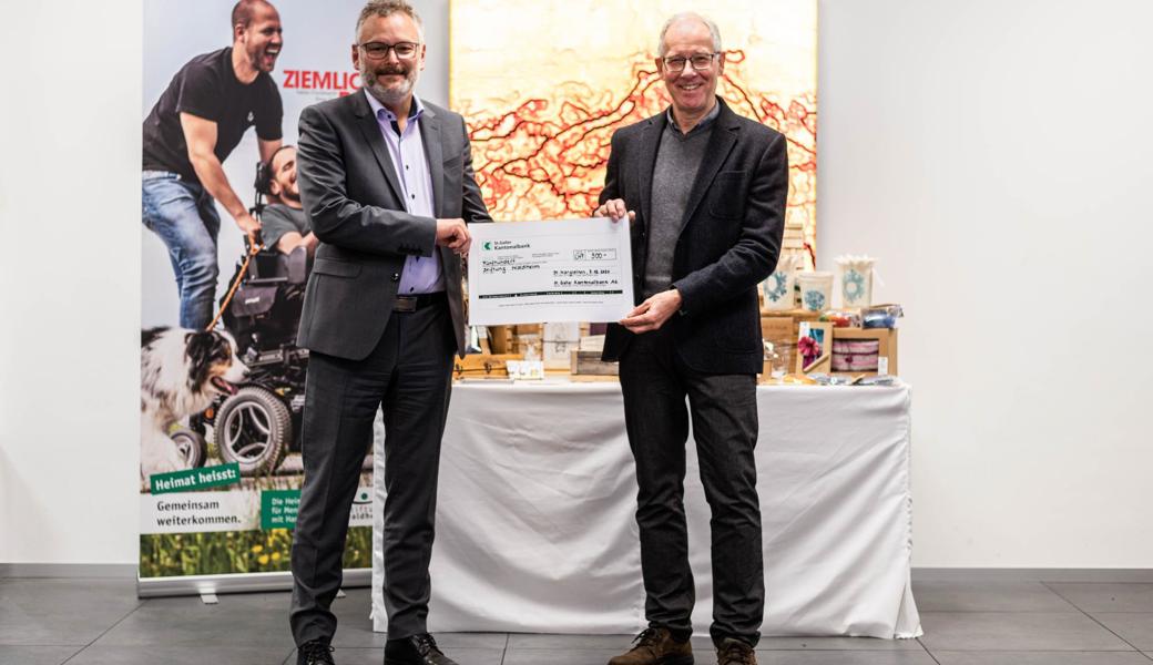 Manfred Seebacher (SGKB-Niederlassungsleiter) überreicht Ueli Graf (Leiter Finanzen Stiftung Waldheim) einen Check über 500 Franken.