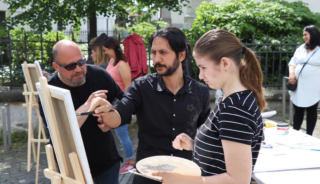 Der aus Afghanistan stammende Künstler Eisa Hashemi (Mitte) malte mit seinen Workshopteilnehmenden die evangelische Kirche Altstätten.
 Der aus Afghanistan stammende Künstler Eisa Hashemi (Mitte) malte mit seinen Workshopteilnehmenden die evangelische Kirche Altstätten.