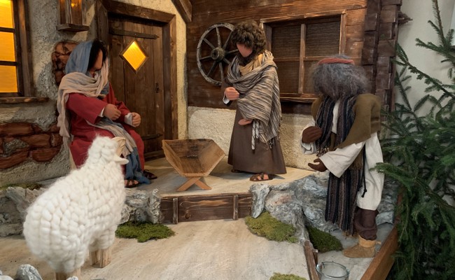 Ein Pfarrer will ein zerbrochenes Jesuskind in die Weihnachtskrippe legen