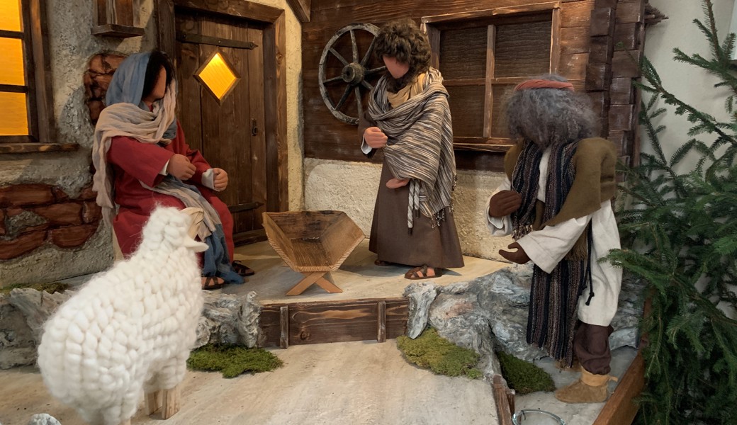 Ein Pfarrer will ein zerbrochenes Jesuskind in die Weihnachtskrippe legen