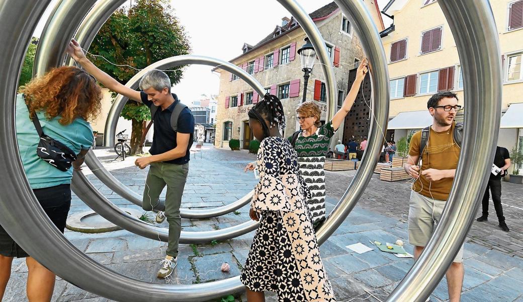Lehrerinnen und Lehrer versuchen sich an der ersten Übung aus dem neuen Lernheft «Mathematische Lernplätze in Altstätten»: Sie schätzten die Länge der Brunnenspirale beim «Frauenhof» und messen nun mithilfe einer Schnur grob nach.