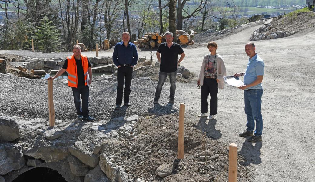 Sie begutachten den sanierten Dorfbach: Ivo Kobler (Leiter Tiefbau, v.l.), Albert Weder (Präsident Ortsgemeinde als Grundeigentümerin), Jürg Dietsche (Dietsche Strassenbau AG), Silvia Troxler (Gemeindepräsidentin) und Roger Dietsche (Projektleiter, Wälli AG Ingenieure).