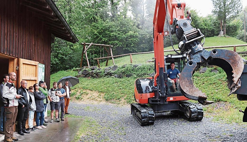 Betriebsleiter Simon Zürcher (links aussen) erklärte die neu erworbenen Geräte, Forstwart Samuel Ulmann führte den Bagger Kubota KX080 vor.