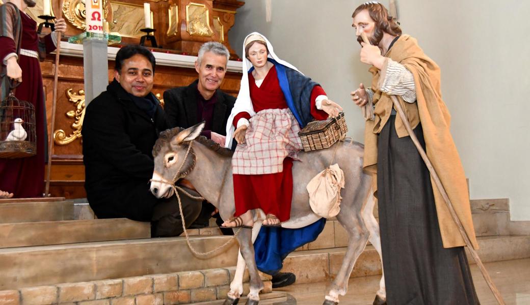 Neue Krippenfiguren in der Josefskirche: Maria und Josef sind auf Herbergssuche. Kaplan Georg Changeth (links) und Präsident Christof Köppel freuen sich über die Neuankömmlinge rechtzeitig zur Weihnacht.
