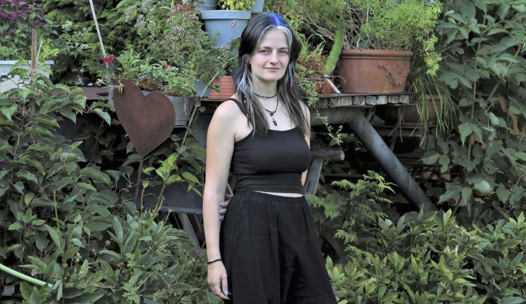 Iris Fritsche im Garten ihrer Eltern auf dem Bauernhof Steigmatt in Montlingen. Entgegen ihren Vorlieben für einen Gothic-ähnlichen Look, wie sie ihn privat trägt, war sie beim Fotoshooting für den Schweizer Bauernkalender ganz in Weiss gekleidet. 
