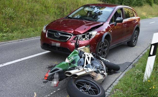 Auto fährt in Motorradfahrer