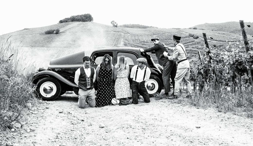 Drei Protagonisten, zwei Begleiterinnen, ein Polizist und ein Citroën Légère: Eine Szene aus dem Clip zu «Je veux aller à Paris».