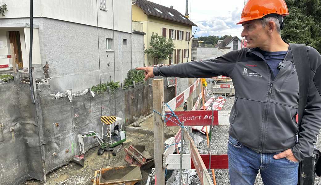 Patrick Rissi vor der Baustelle. Im Bachbett zu sehen ist die orange Mulde, mit der erneut angeschwemmtes Material entfernt wird. 