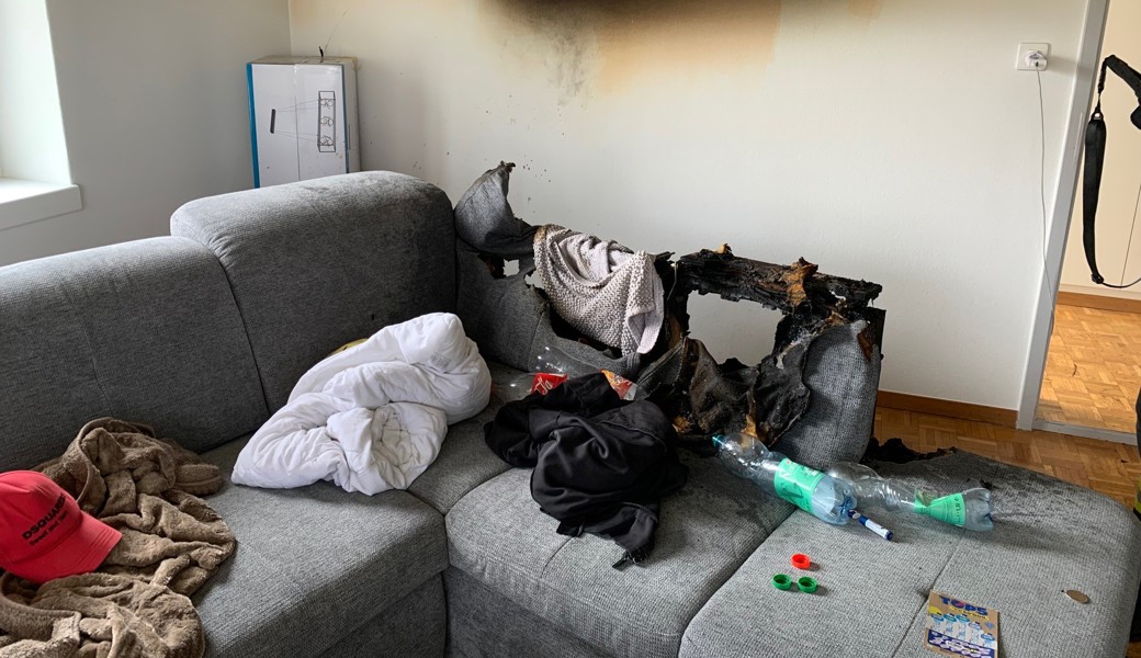Das Polstermöbel wurde arg in Mitleidenschaft gezogen. Die Feuerwehr trug es hinaus.