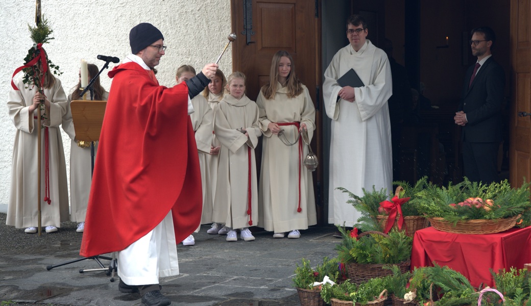 Pfarrer Roman Karrer segnet die Körbe mit Palmzweigen und Äpfeln