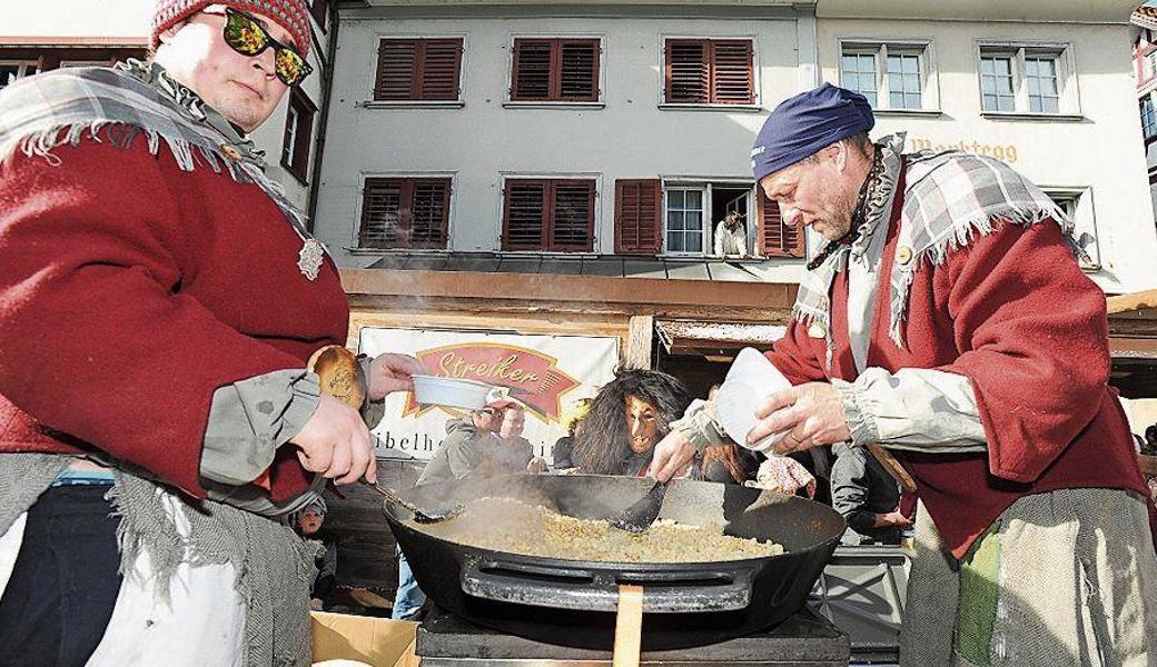 Die Altstätter Ribelbüüchwiiber verwöhnen ihr Publikum: Es bekommt frisch gebratenen Ribel ab dem fahrenden Umzugswagen.