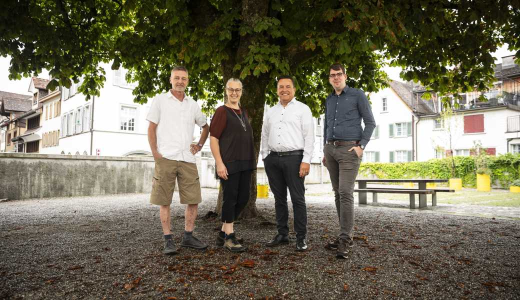 Die Sitzbank wird um den Kastanienbaum im Museumsgarten platziert, von links: Guido Poznicek (Schule), Monika Meyer (Museumskuratorin), Toni Loher (Stadtrat) und Elias Meile (Katholische Kirchgemeinde sind gespannt auf das Ergebnis. 