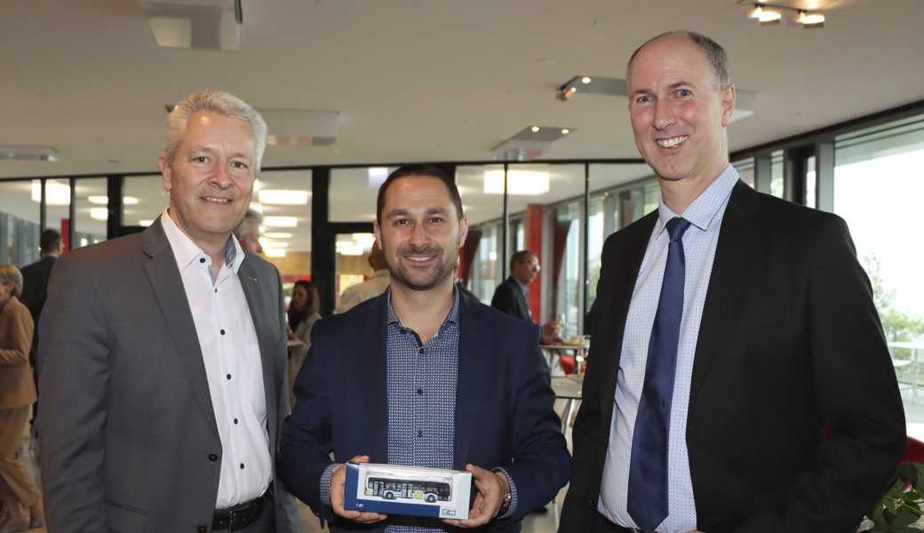 Verwaltungsratspräsident Daniel Wild (l.) und Unternehmensleiter Roland Ochsner (r.) gratulieren dem frisch gewählten Verwaltungsrat ­Gabriel Macedo zu seiner Wahl und überreichen ihm einen Modellbus. 