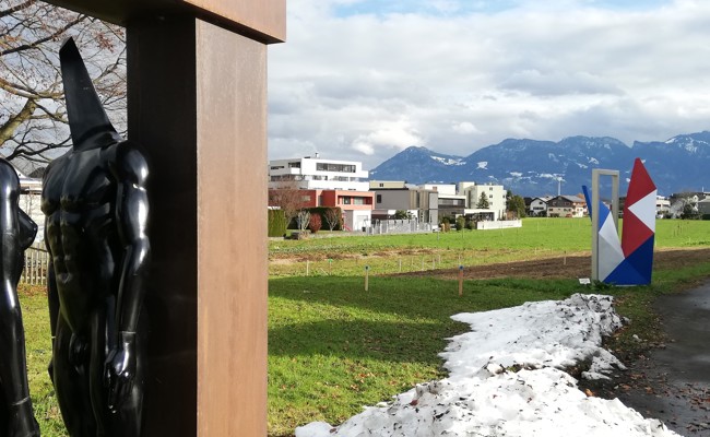 Was die farbig angesprühten Holzpflöcke auf der Wiese hinter den Kunstwerken bedeuten