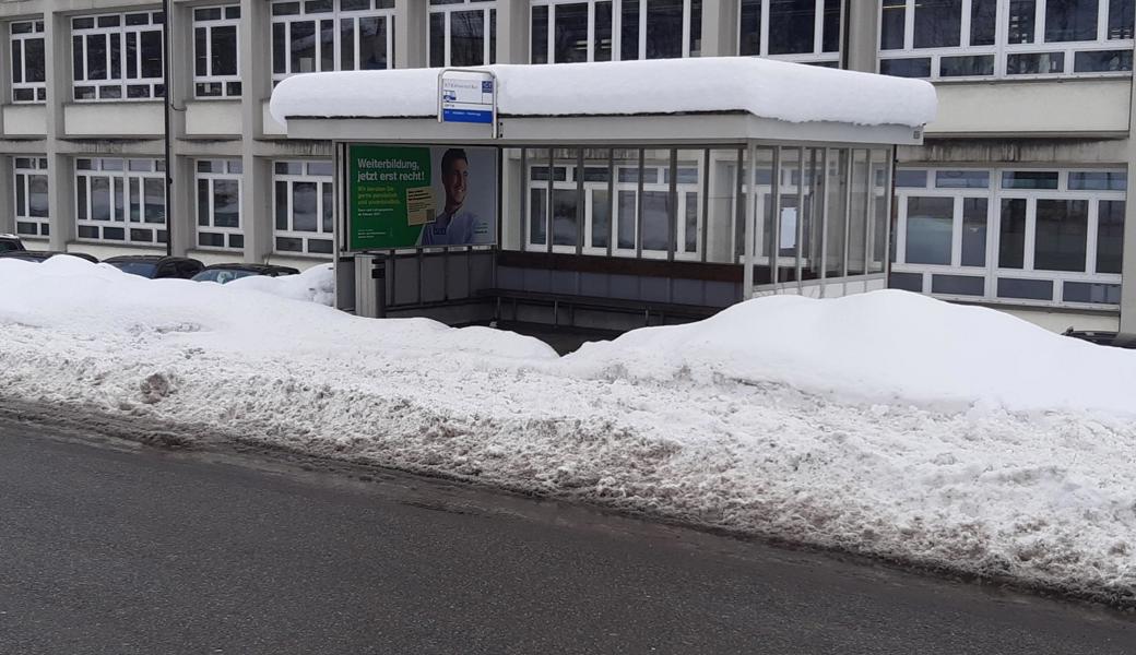 Bushaltestelle bei der Leica mit verschneitem Trottoir.