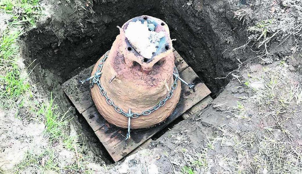 Die Glocke in der Lehmform kühlt in einer Grube aus.