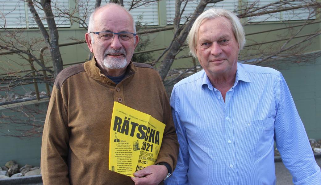Bruno Städler (links) und Thomas Hubatka sind Mitglieder der «Rätscha»-Kommission und freuen sich über die neue, umfangreichere Fasnachtszeitung der Fasnachtsmontags-Clique. (Abgebildet ist die Nummer von 2021, weil jede Ausgabe bis zum Erscheinen ein streng gehütetes Geheimnis ist.) 