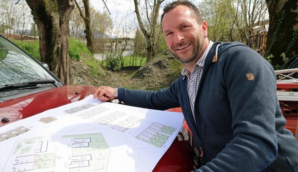 Präsident Bernhard Schneider beugt sich über die Pläne möglicher Mehrfamilien- und Doppeleinfamilienhäuser auf der Parzelle Riethüsli am südlichen Dorfrand von Rüthi.