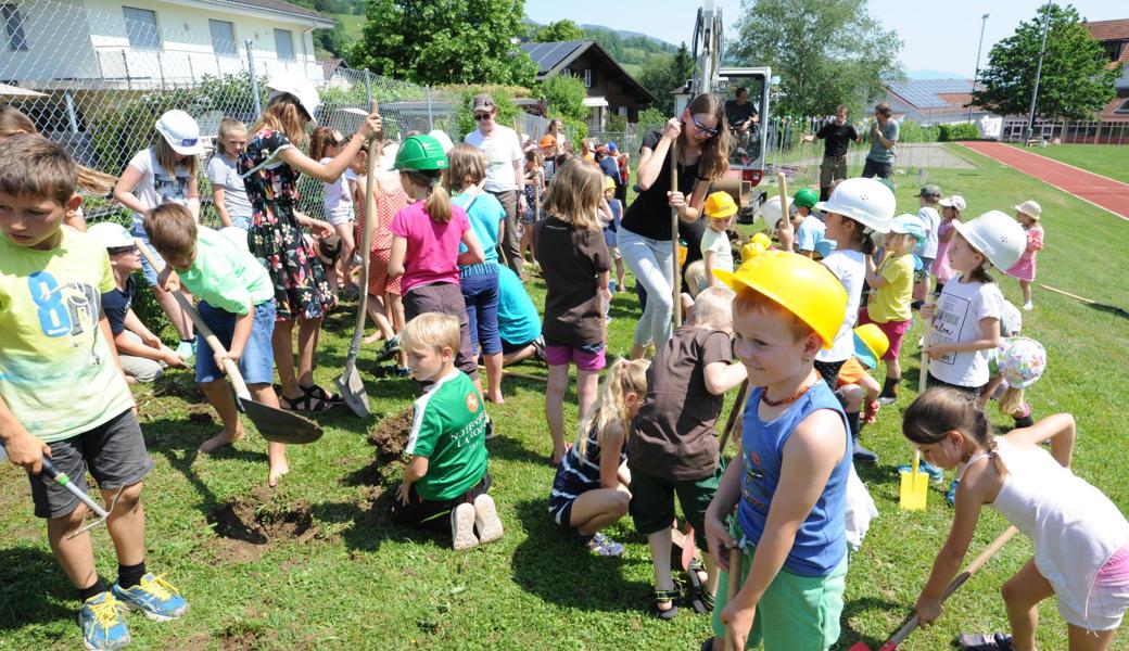 Stechen, hacken, schaufeln: Hinterforsts Kinder mühen sich beim Spatenstich für ihr Biotop gehörig ab – gut, macht nachher der Bagger weiter. Zwischen den Kindern arbeitet Initiantin Malin Wiget (im schwarzen Shirt) fleissig mit.Bild: Max Tinner
